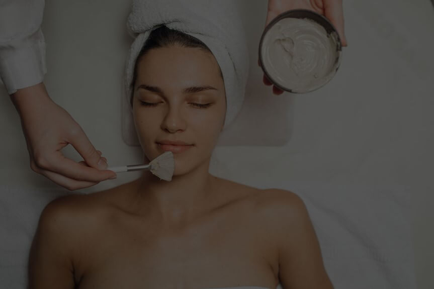 A smiling woman enjoying an expert massage service at Hand & Stone Massage and Facial Spa.